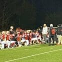 Smyrna football huddles after a big victory near the scoreboard photo courtesy of Smyrna Eagles Max Preps
