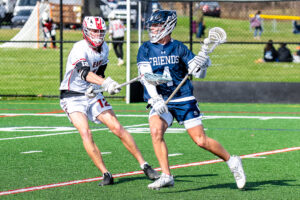 Photo Gallery: Smyrna vs Friends Boys Lacrosse 5 Smyrna long stick midfielder senior Reed Schultz(12) defends against Friends' senior Benjamin Osbourn (4)