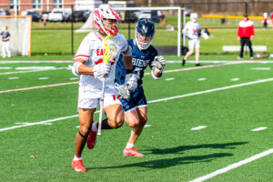 Photo Gallery: Smyrna vs Friends Boys Lacrosse 6 Smyrna senior Michael Sebastian (14) is defended upfield by Friends senior Nathan Bell (7)