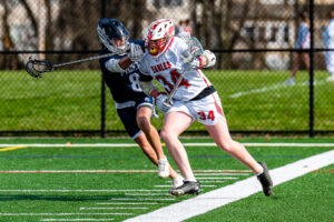Photo Gallery: Smyrna vs Friends Boys Lacrosse 8 Smyrna attackman Grayson Judy (34) protects the ball as he moves towards the middle of the field while being defended by Friends Stone Davis (88)
