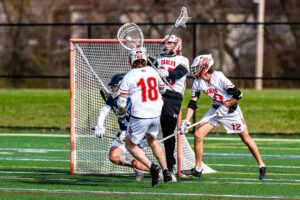 Photo Gallery: Smyrna vs Friends Boys Lacrosse 13 Smyrna goalie Boe Evans(35) makes the save against Friends Benjamin Osbourn (4) after being checked by Smyrna's Reed Schultz (14) and Jake Supinski (18)
