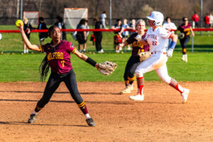 Milford senior Rihanna Adams is poised as she gets ready to fire to first, despite a Smyrna runner near the play.
