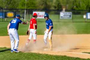 A Dover player celebrates sliding into third base.