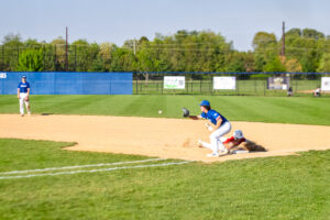 A Smyrna player dives back into first base returning to the base safely.