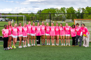 The Smyrna girls lacrosse team sports their pink warm up shirts celebrating their "Go Pink Game".