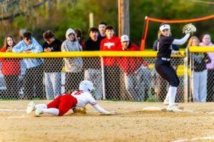 Smyrna senior Alyssa Spicer dives into the base as fans look on over the fence.