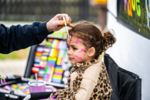 Southpaw Studios was on hand to provide face painting to attendees. Here Camryn Lawrence is getting the final touches done to her face paint.