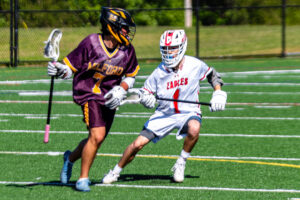 Fruehauf (7) surveys the Smyrna defense while being defended by Smyrna senior Tannin Bell. The Buccaneers scored five goals in the second half.