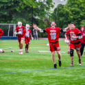 Supinski (18), senior Timothy Pepeta (20), junior Christopher Nacrelli (4) and sophomore Alec Elwood (32) celebrate the win as rain comes down as it did during the game.